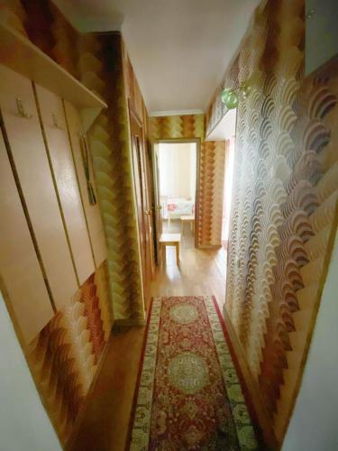 a room with a hallway with a rug and a table at Квартира напротив Аэропорта in Turksib