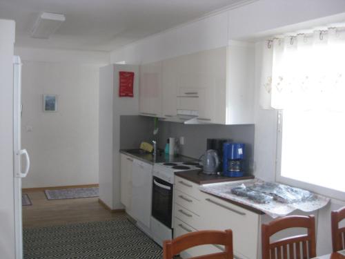 a kitchen with white cabinets and a stove top oven at Huoneistomajoitus Hella 3C Härmä in Härmä