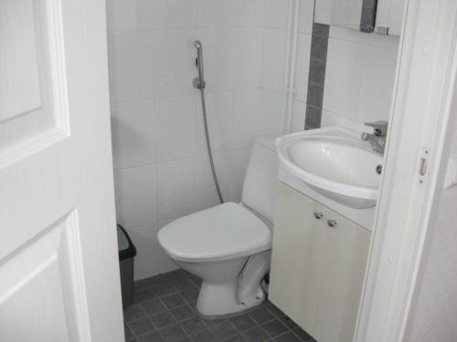 a white bathroom with a toilet and a sink at Huoneistomajoitus Hella 3C Härmä in Härmä