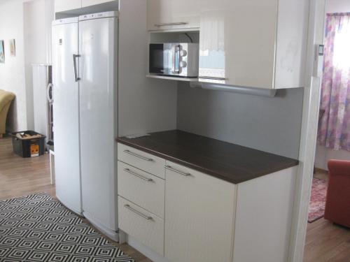 a kitchen with white cabinets and a refrigerator at Huoneistomajoitus Hella 3C Härmä in Härmä