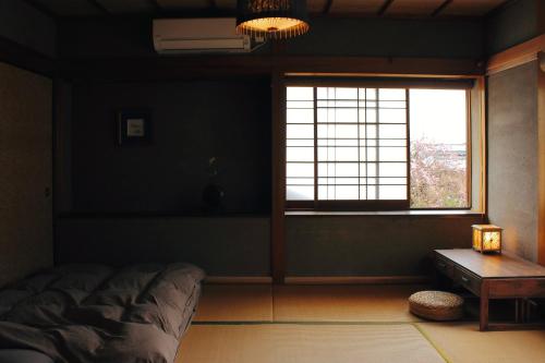 a bedroom with a bed and a window and a table at 神倉書斎 [Kamikura-Hideaway] in Shingu