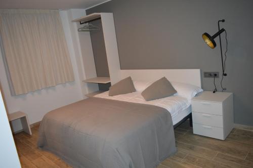 a small bedroom with a bed and a lamp at Mas Piua in Girona