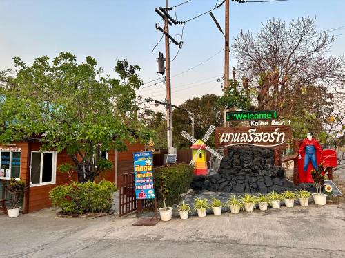 a windmill and a sign in front of a building at Kalae Resort in Ban Nong Ben