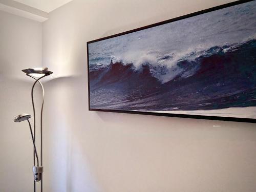 Un televisor de pantalla plana colgado en una pared en Apartamento Barrio de la Arena, en Gijón