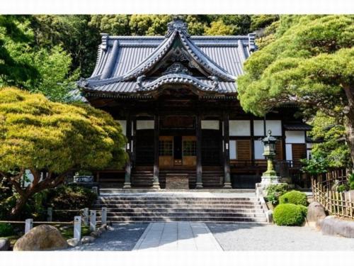 an asian style building with stairs in a garden at Breezbay Shuzenji Hotel in Izu