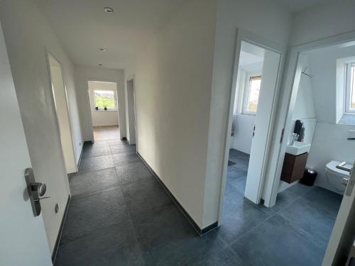 - un couloir menant à une salle de bains pourvue de toilettes dans l'établissement Ferienwohnung Niederbarge, à Barge