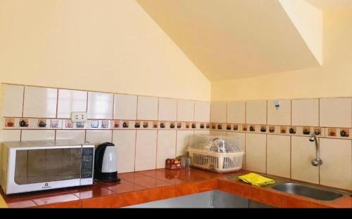 a kitchen with a microwave and a sink at House explorer in Cusco