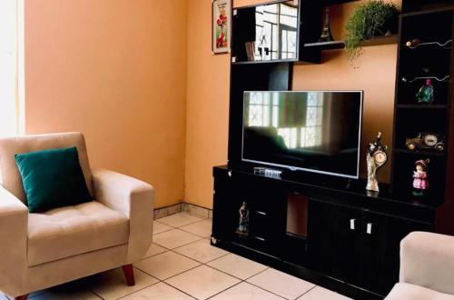 a living room with a television and a chair at House explorer in Cusco