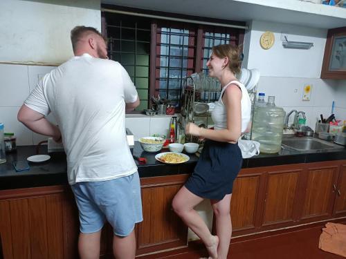 a man and woman standing in a kitchen preparing food at Angels' homestay Marari in Mararikulam
