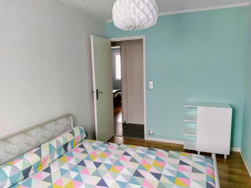 um quarto com uma cama e um piso colorido em Maison plain pied avec jardin, terrasse et veranda em Cognac