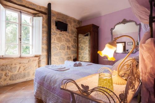 1 dormitorio con 1 cama con mesa y espejo en Borgo Tepolini Country House, en Castel del Piano