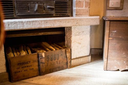 a pile of boxes sitting on the floor next to a fireplace at Chalet Relax Tra Le Vigne in Forni di Sotto