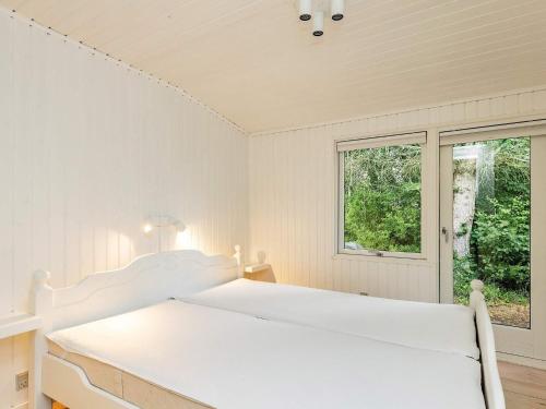 - une chambre blanche avec un lit et une fenêtre dans l'établissement Holiday home Hals CXXIX, à Hals