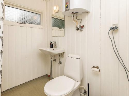 Baño blanco con aseo y lavamanos en Holiday home Hals CXXIX, en Hals