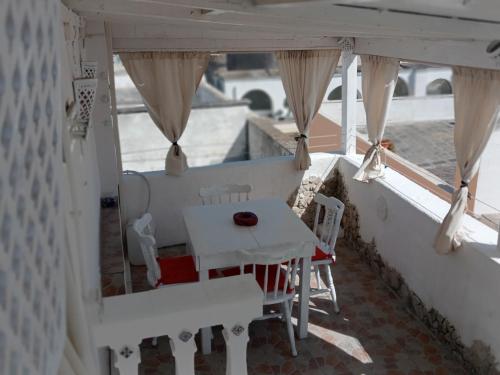 balcón con mesa, sillas y ventana en ATTICO D'ANGIO', en Gallipoli