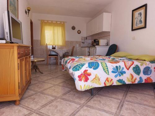 a bedroom with a bed with a colorful bedspread on it at Apartments Vista Montaña Roja in Atogo