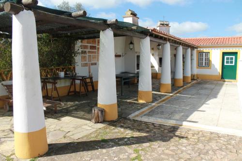 a row of columns of a house with a table at Montinho do Palanque in Viana do Alentejo