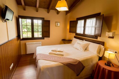 クディレロにあるApartamentos Rurales Villa de Sain Cudilleroのベッドルーム1室(ベッド1台、タオル2枚付)
