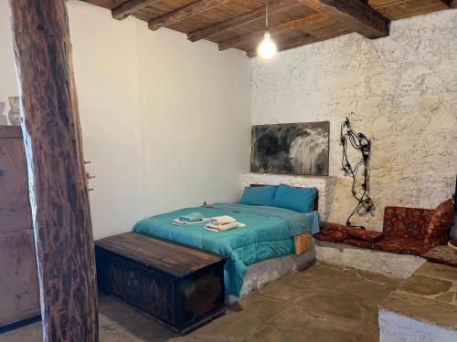 a bedroom with a bed with a blue comforter at The traditional hause with the best view in Leonidion