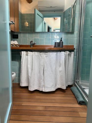 a bathroom with a sink and a shower with white towels at Elegant apartment with sea view in Monterosso al Mare