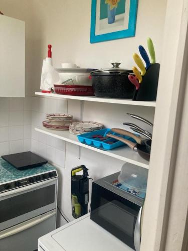 - une cuisine avec des étagères, de la vaisselle et des ustensiles dans l'établissement Un appartement au château de Locquéran Finistère, à Plouhinec