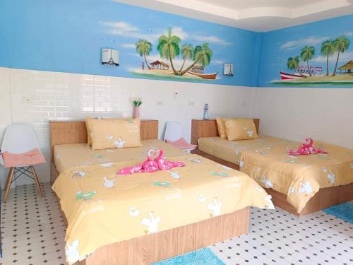 a bedroom with two beds with pink dolls on them at Sichon Lalla Beach สิชล ลัลลา บีช in Sichon