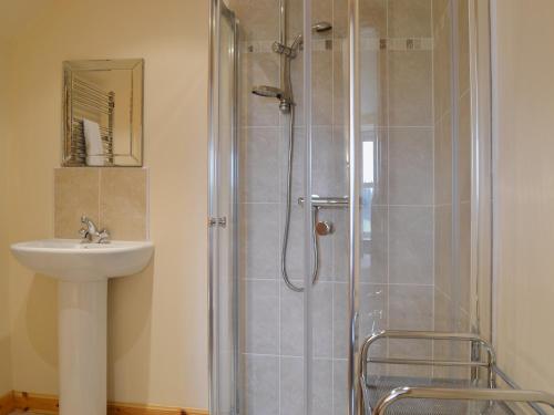 y baño con ducha y lavamanos. en Stable Cottage - Beaufort Estate, en Belladrum