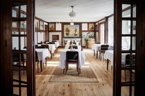jadalnia z białymi stołami i krzesłami w obiekcie Hotel Strandly Skagen w mieście Skagen