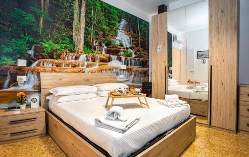 - une chambre avec un lit et une fresque murale représentant une cascade dans l'établissement Sorrento Mahal Kita Lovely 6-Bed in Sorrento, à Sorrente