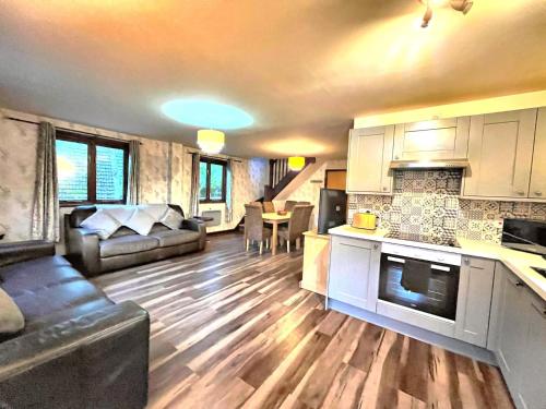a kitchen and living room with a couch and a table at BlueBell 16-Hot Tub-Woodland Lodges-Pembrokeshire in Carmarthen