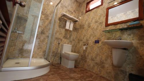 a bathroom with a shower and a toilet and a sink at Hong Bin Bungalow in Phu Quoc
