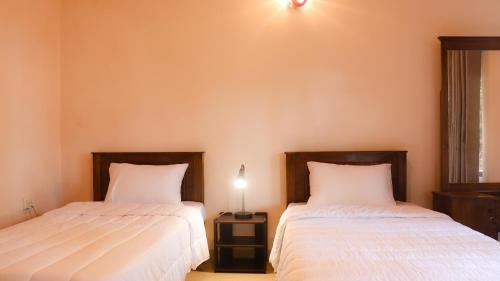two beds sitting next to each other in a bedroom at Hideaway Homestay kandy in Haloluwa