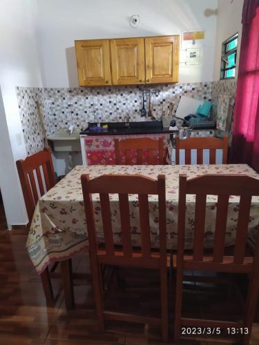 a kitchen with a table and chairs with a table and a kitchen at Hostel el Amanecer in Puerto Iguazú