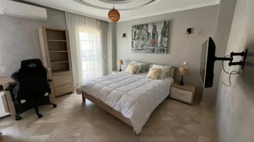 een slaapkamer met een bed, een bureau en een stoel bij Villa Jasmina Targa in Marrakesh