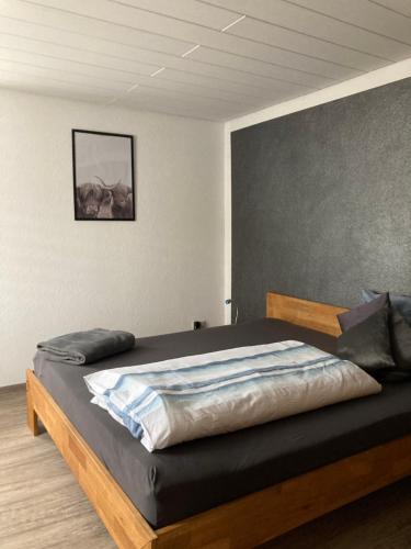 ein Schlafzimmer mit einem großen Bett mit einem Holzrahmen in der Unterkunft Ferienwohnung Petra in Rust