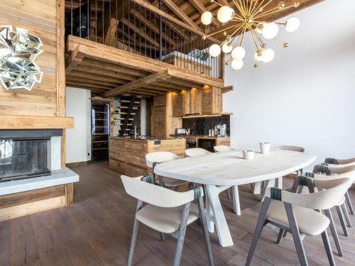 une salle à manger avec une table et des chaises et une cheminée dans l'établissement Duplex 5 pièces luxe aux pieds des pistes avec hammam et cheminée - FR-1-694-87, à Val dʼIsère