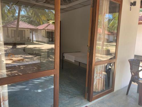 a door to a room with a bed and a window at Sea Sand Resort in Kalpitiya