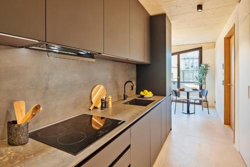 a kitchen with a sink and a counter top at Liv Suites - Self Check-in in Luzern