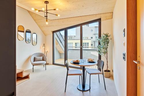 uma sala de jantar com mesa e cadeiras em Liv Suites em Lucerna