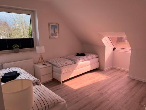 Zimmer im Dachgeschoss mit 2 Betten und einem Fenster in der Unterkunft Großzügige 3 ZKB mit 80m² in Wilhelmshaven