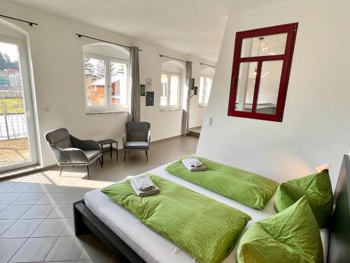 een slaapkamer met 2 bedden, een stoel en ramen bij Meißner Elb-Domizil 2 in Meißen