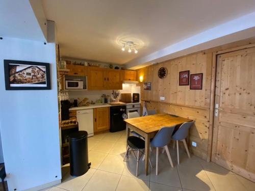 a kitchen with a wooden table and chairs at LE RUCHER DE LA VIGNETTE in Le Grand-Bornand