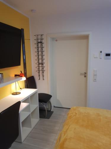 um quarto com uma cama, uma secretária e uma porta em Klein und fein em Erftstadt