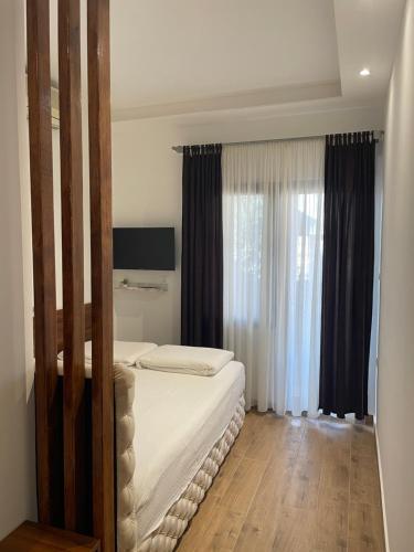 a bedroom with a bed and a large window at Villa i SPA Stević in Veliko Gradište