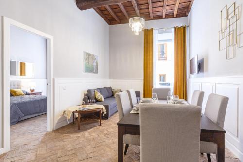 ein Wohnzimmer mit Esstisch und Couch in der Unterkunft CasAlice Apartments Roma Trevi in Rom