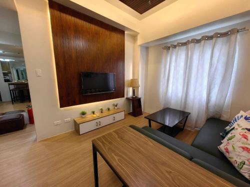 sala de estar con sofá y TV de pantalla plana en 2 BR Loop Tower 1524, en Cagayan de Oro