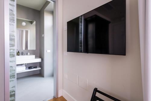 a bathroom with a television hanging on the wall at Belvedere in Stresa