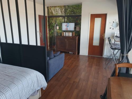 une chambre avec un lit, une table et une télévision dans l'établissement Chambre d amour, à Anglet