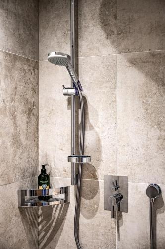 a shower with a shower head in a bathroom at Nativo Bergaparts - Summercard inklusive in Längenfeld