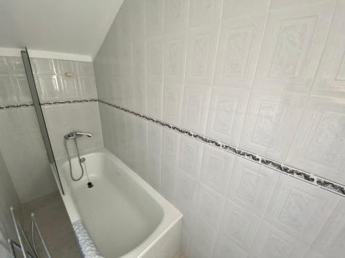 a white bathroom with a bath tub and a shower at Ericeira Sand Beach F5 in Ericeira